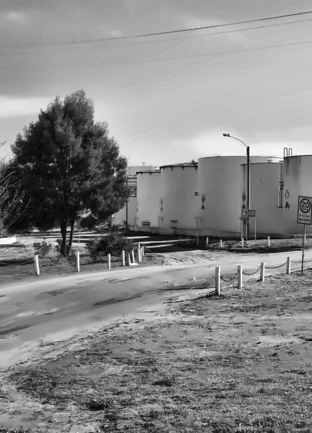 Storage tanks next to the green buffer zone on the plant perimeter